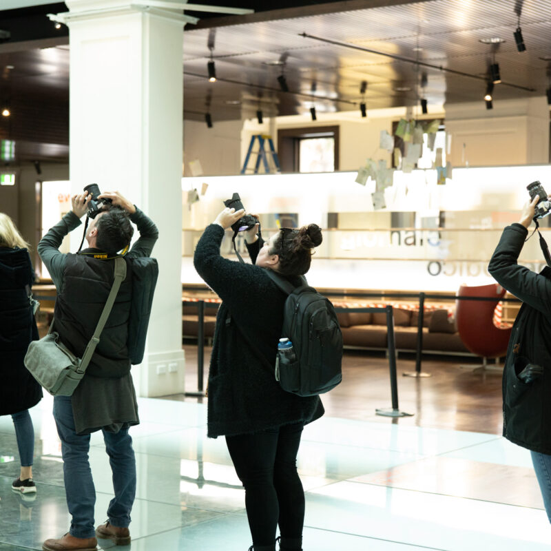 Photography students capturing architectural features during indoor workshop session in Sydney