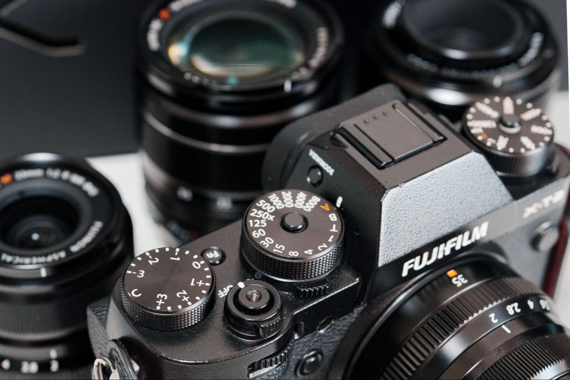 Fujifilm mirrorless camera surrounded by prime lenses