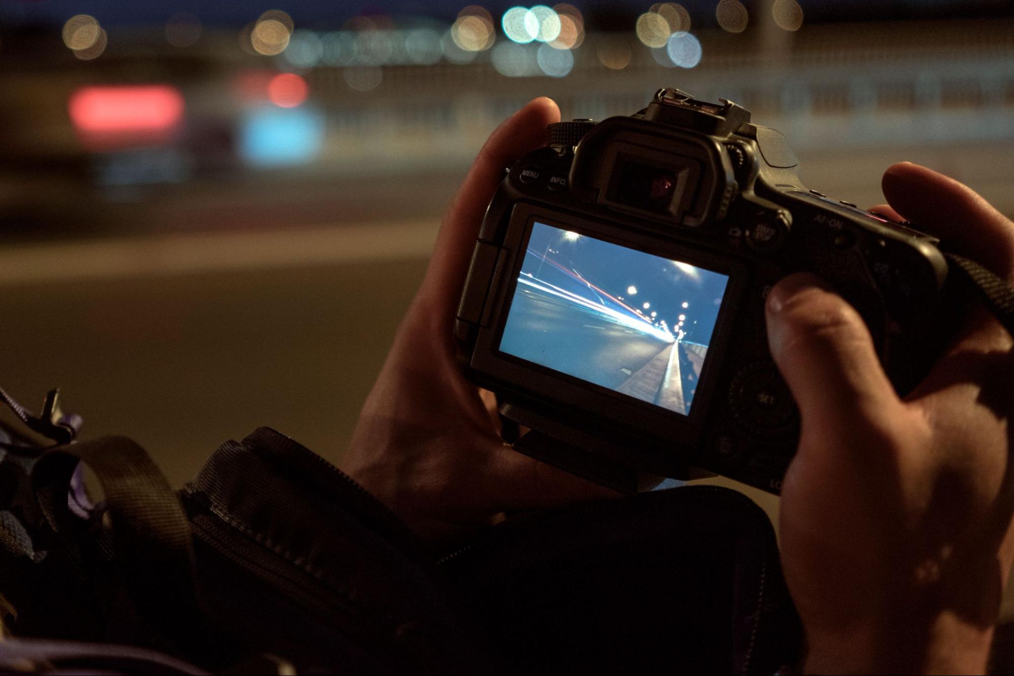 Photographer checking a night exposure on the camera rear screen