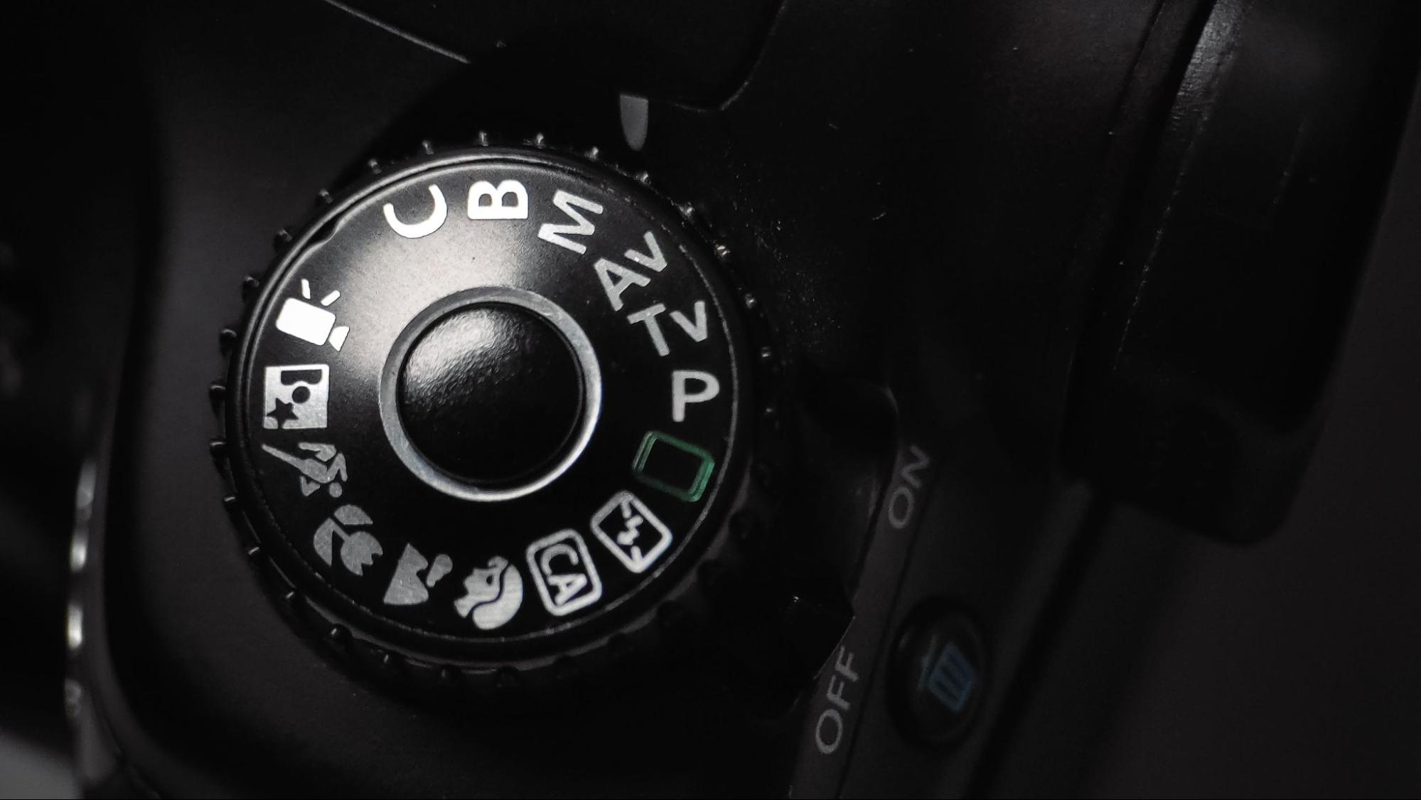 Close-up of a camera mode dial showing Manual, Aperture Priority and Shutter Priority