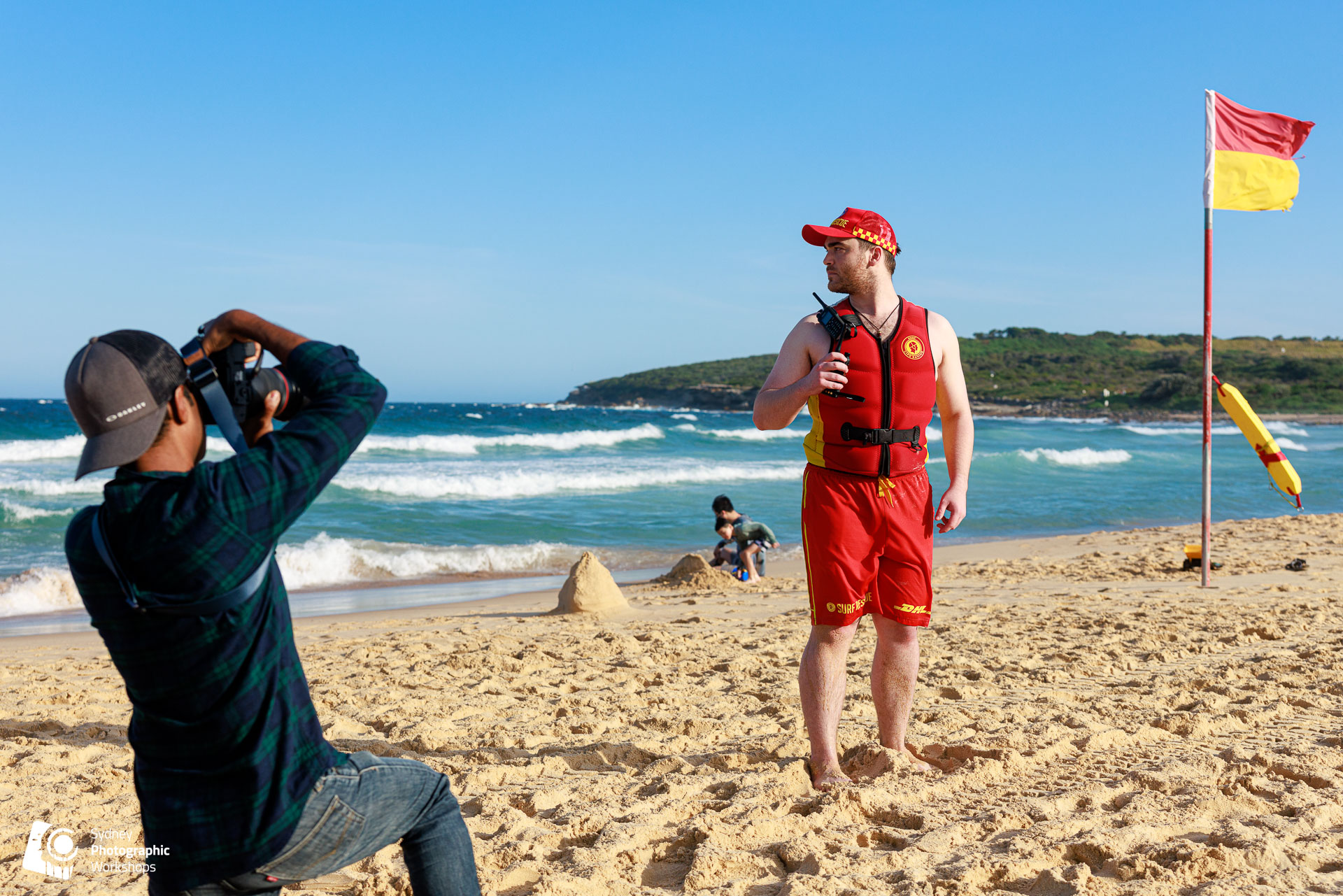 A workshop participant photographing a surf lifesaver on a Sydney beach